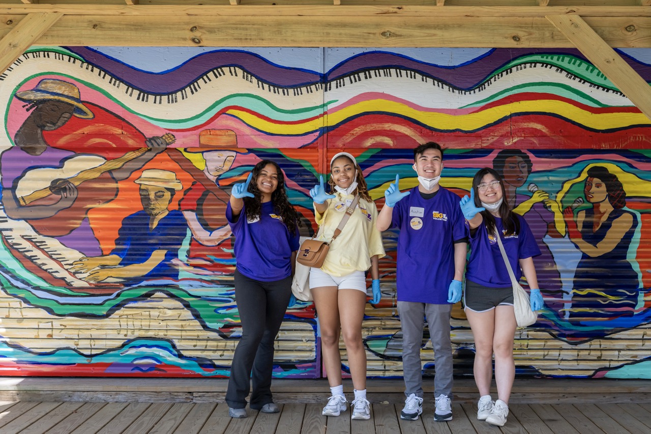 Geaux Big participants pose in front of mural
