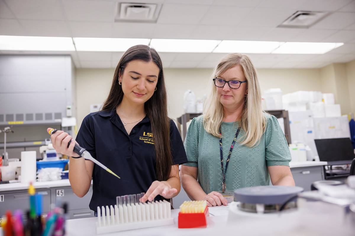 Erin Oberhaus in lab with a student