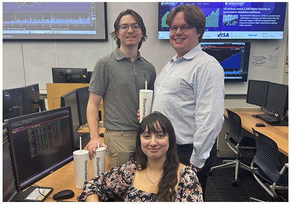 Members of the Tiger Fund team stand in front of financial data screens.