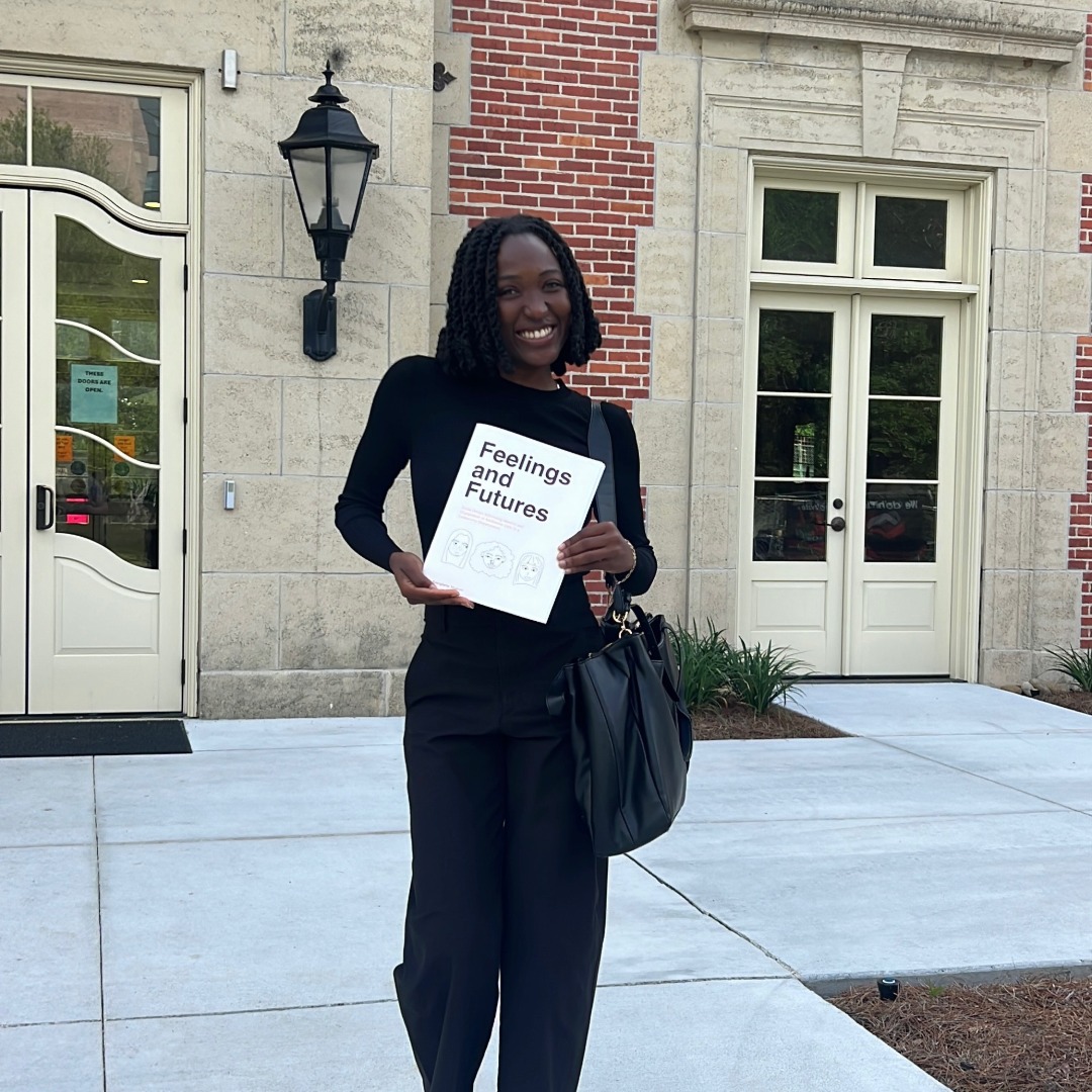 Photo of LSU Ogden Honors College graduate Ese Mukuro in front of the French House with her Capstone