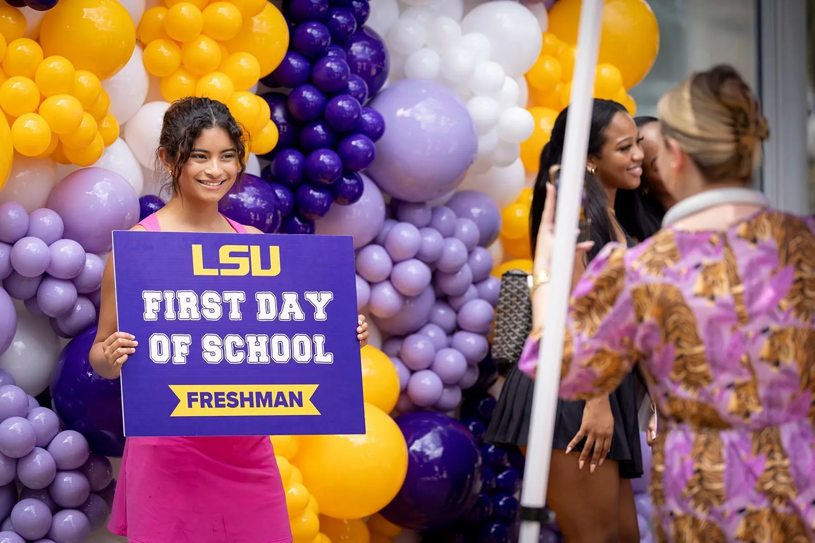 New Freshman holding a sign that reads LSU First Day of School Freshman and posing for a picture